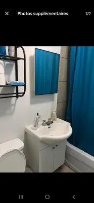 a bathroom with a white sink and a toilet at Chambre spacieuse in Montréal
