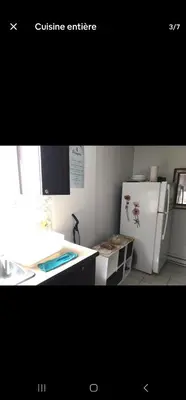 a kitchen with a white refrigerator and a counter at Chambre spacieuse in Montréal