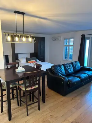 a living room with a couch and a table and a bed at Condos hotel lion d or in Magog-Orford