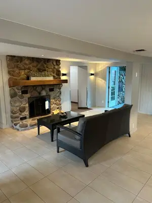 a living room with a table and a stone fireplace at Condos hotel lion d or in Magog-Orford
