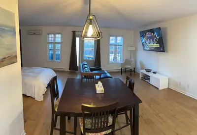a living room with a dining table and a bed at Condos hotel lion d or in Magog-Orford