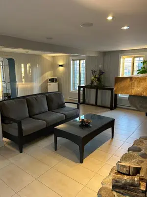 a living room with a couch and a table at Condos hotel lion d or in Magog-Orford
