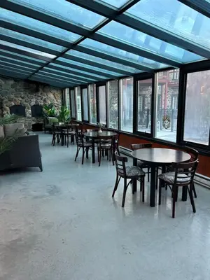 a large room with tables and chairs and windows at Condos hotel lion d or in Magog-Orford