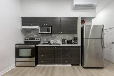 a kitchen with a stainless steel refrigerator and appliances at Three bedroom chic condo downtown Montreal in Montréal