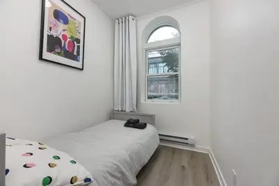 a bedroom with a bed and a window at Three bedroom chic condo downtown Montreal in Montréal
