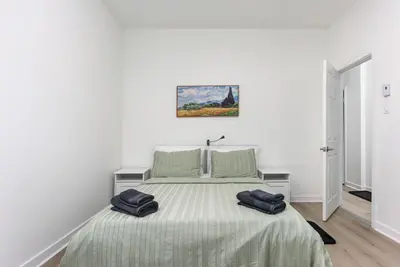 a white bedroom with a bed with two bags on it at Three bedroom chic condo downtown Montreal in Montréal