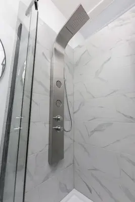 a shower with a glass door in a bathroom at Three bedroom chic condo downtown Montreal in Montréal
