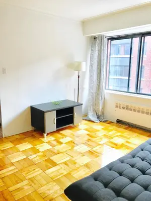 a living room with a wooden floor and a couch at Stylish Montreal Apartment Comfortable Stay in the Golden Square Mile in Montréal