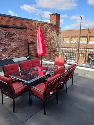a table with chairs and a red umbrella on a patio at Huge 3 Bedroom Condo with a Large Patio in Montréal