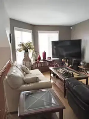a living room with a couch and a table at Villa le Voyageur in Sherbrooke