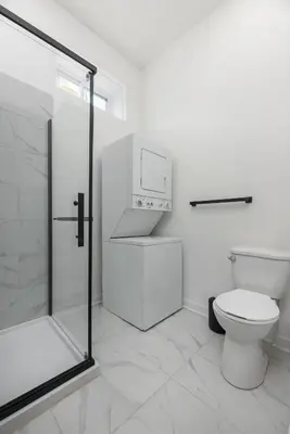 a white bathroom with a toilet and a shower at Brand new 2 bedroom in the heart of the city in Montréal