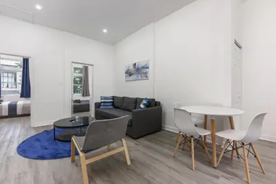 a living room with a couch and a table and chairs at Brand new 2 bedroom in the heart of the city in Montréal