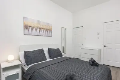 a bedroom with a bed and a painting on the wall at Brand new 2 bedroom in the heart of the city in Montréal