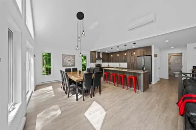 a kitchen and dining room with a table and chairs at Chalet Le PÜR in Eastman