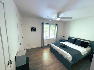 a bedroom with a bed with a ceiling fan at Chalet Le PÜR in Eastman