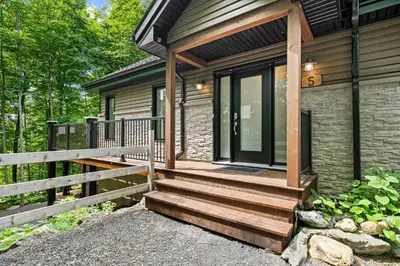 a front porch of a house with a wooden deck at Chalet Le PÜR in Eastman