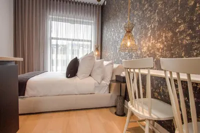 a bedroom with a bed and a window and a chair at Studio #2 - Self Check-In - Plateau - St-Denis in Montréal