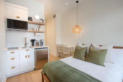 a bedroom with a bed and a kitchen in it at Studio #3 - Self Check-In - Plateau - St-Denis in Montréal