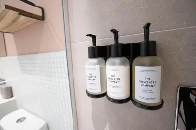 three bottles of moisturizers on a wall in a bathroom at Studio #3 - Self Check-In - Plateau - St-Denis in Montréal