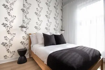 a bedroom with a black and white bed and a window at Studio #4 - Self Check-In - Plateau - St-Denis in Montréal