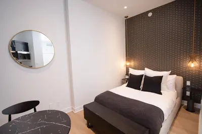 a bedroom with a bed and a mirror and a chair at Studio #5 - Self Check-In - Plateau - St-Denis in Montréal