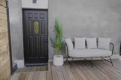 a porch with a couch and a plant in front of a door at Studio #6 - Self Check-In - Plateau - St-Denis in Montréal