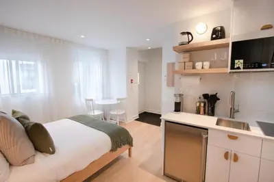 a bedroom with a bed and a kitchen with a sink at Studio #7 - Self Check-In - Plateau - St-Denis in Montréal