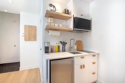 a small kitchen with white cabinets and a sink at Studio #7 - Self Check-In - Plateau - St-Denis in Montréal