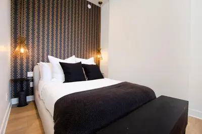 a bedroom with a bed with black and white pillows at Studio #8 - Self Check-In - Plateau - St-Denis in Montréal