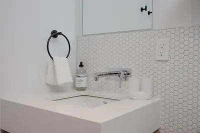 a white bathroom with a sink and a mirror at Studio #9 - Self Check-In - Plateau - St-Denis in Montréal