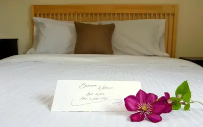 a note on a bed with a flower on it at Objectif Santé in Longueuil