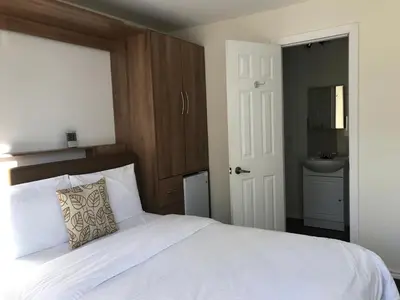 a bedroom with a white bed and a sink at Objectif Santé in Longueuil