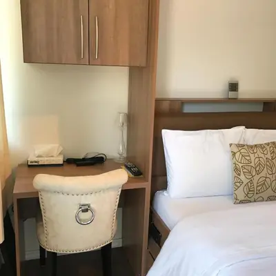 a hotel room with a desk with a bed and a phone at Objectif Santé in Longueuil