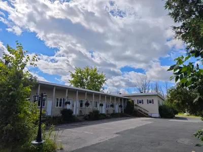 a large white building with a parking lot at Objectif Santé in Longueuil
