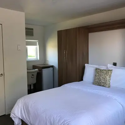 a bedroom with a large white bed with a wooden headboard at Objectif Santé in Longueuil