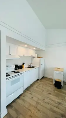 a white kitchen with a stove and a refrigerator at Escape Mont Orford in Magog-Orford
