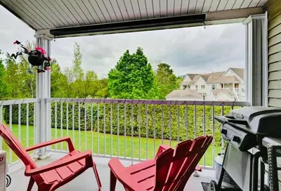 a porch with red chairs and a large window at Escape Mont Orford in Magog-Orford