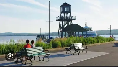 two people sitting on benches in front of a lighthouse at Escape Mont Orford in Magog-Orford