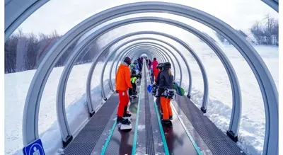 a group of people walking through a tunnel on skis at Escape Mont Orford in Magog-Orford
