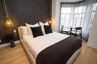 a bedroom with a large bed with black and white pillows at Studio #13 - Self Check-In - Plateau - St-Denis in Montréal