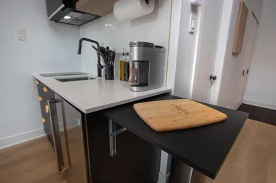 a kitchen with a counter with a wooden cutting board on it at Studio #13 - Self Check-In - Plateau - St-Denis in Montréal