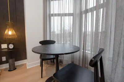 a black table and chair in a room with a window at Studio #13 - Self Check-In - Plateau - St-Denis in Montréal