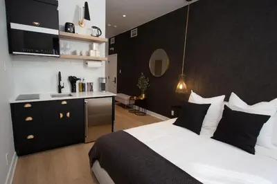 a bedroom with a large bed and a kitchen at Studio #13 - Self Check-In - Plateau - St-Denis in Montréal