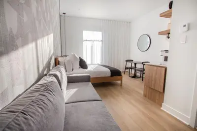 a bedroom with a bed and a couch and a table at Studio #14 - Self Check-In - Plateau - St-Denis in Montréal