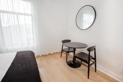 a bedroom with a table and a mirror next to a bed at Studio #14 - Self Check-In - Plateau - St-Denis in Montréal