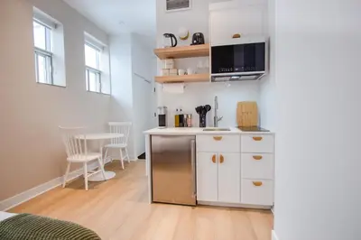 a kitchen with white cabinets and a microwave at Studio #16 - Self Check-In - Plateau - St-Denis in Montréal