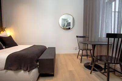 a bedroom with a bed and a table and a mirror at Studio #17 - Self Check-In - Plateau - St-Denis in Montréal