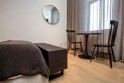 a bedroom with a table and two chairs and a mirror at Studio #17 - Self Check-In - Plateau - St-Denis in Montréal