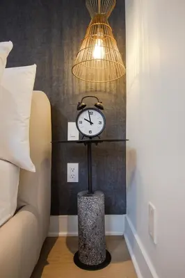 a clock on a stand in a room with a lamp at Studio #17 - Self Check-In - Plateau - St-Denis in Montréal