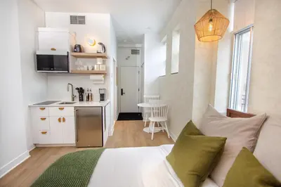a bedroom with a bed and a small kitchen at Studio #18 - Self Check-In - Plateau - St-Denis in Montréal
